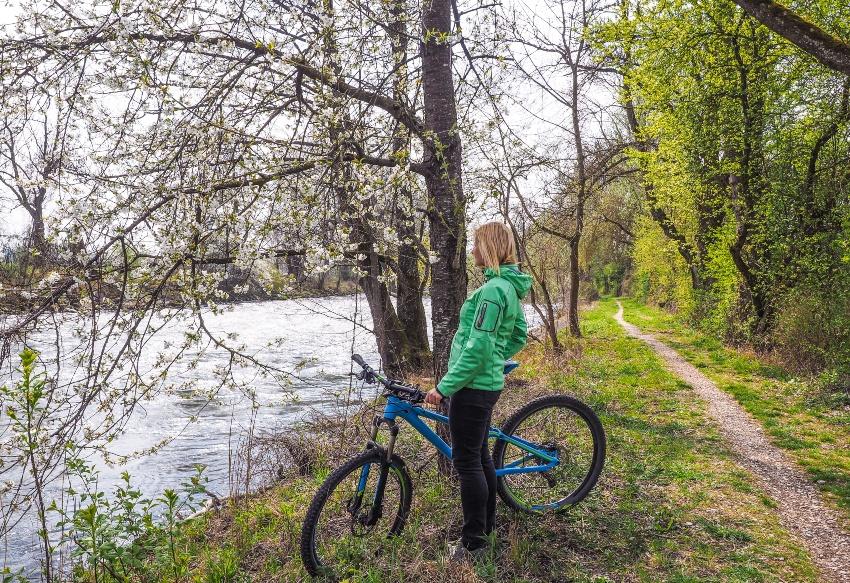 Junge Frau macht Pause mit dem Fahrrad an einem Fluss