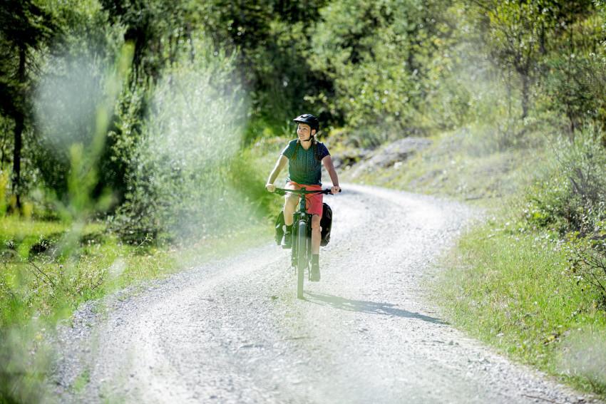 Für eine Tagestour eignet sich zum Beispiel ein Rundweg im Allgäu Frau auf einem Fahrrad im Grünen - Packliste für den Radurlaub