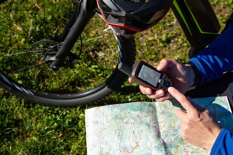Jemand schaut auf sein Handy zur Orientierung bei einer Radtour - Fahrradtour planen
