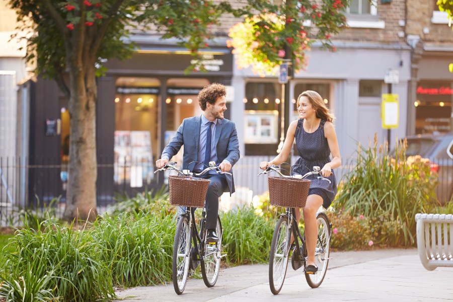 Mann und Frau fahren mit dem Fahrrad zur Arbeit - 8 Gründe mit dem Fahrrad zur Arbeit zu fahren