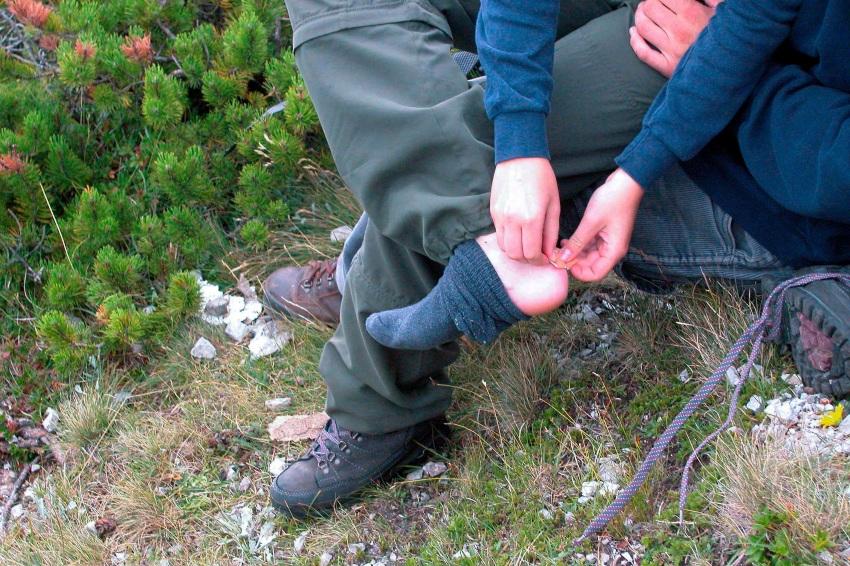 Wer gleich am Anfang zu viel will, bezahlt in der Regel einen unnötigen Preis in Form von Schmerzen Mann behandelt Blasen vom Wandern - Wandern für Anfänger: Wie viele Kilometer schaffen wir?