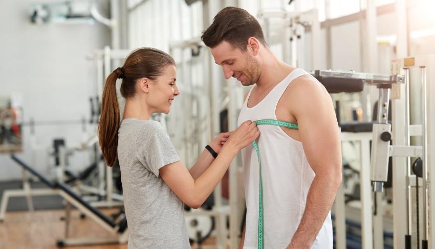 Frau-misst-Brustumfang-von Mann - Brustumfang richtig messen