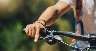 Mann greift Fahrradlenker mit rechter Hand, hand ist im Fokus