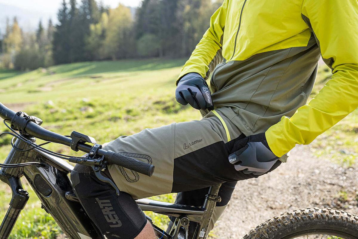 Im besten Falle sollten Sattel und Rumpfmuskulatur den größten Teil des Gewichts tragen. Hier lohnt es sich, den Sattel sowie Lenker richtig einzustellen. Mann sitzt bei einer Pause auf Fahrradsattel und schließt Tasche an seiner Hose